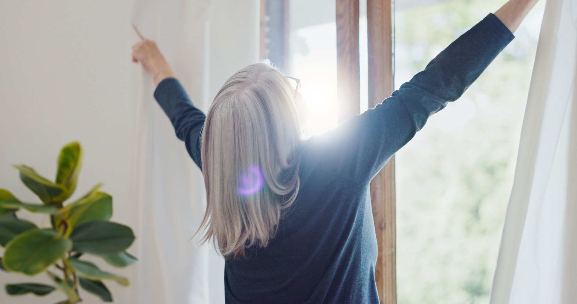 Elderly woman in home, opening curtains and getting ready for the day with sun, light and fresh air. Morning routine, retirement and senior person at window in apartment, housework and chores in room